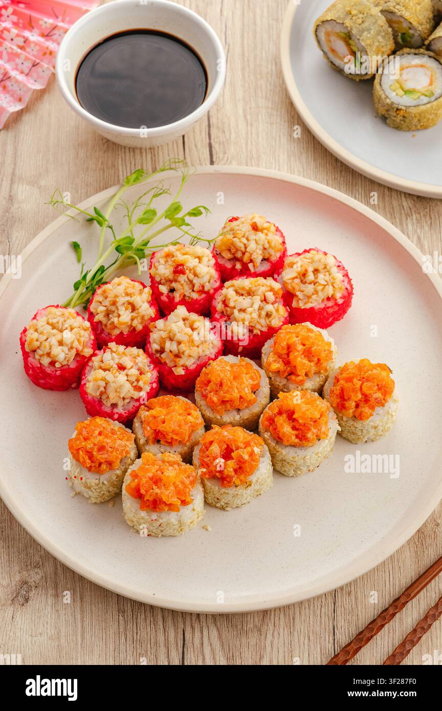Verschiedene japanische Sushi-Rollen auf einem Holztisch Stockfoto