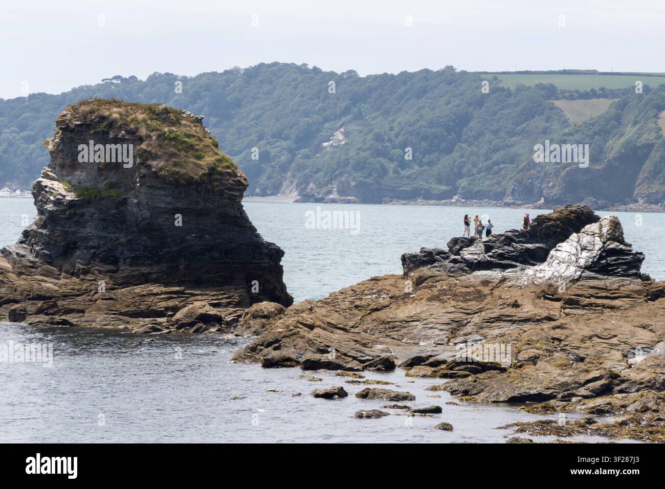 Cornwall 2026 Charlestown, England - 16.7.2026: Touristen auf einem Felsen am Hafen von Charlestown. England Stockfoto