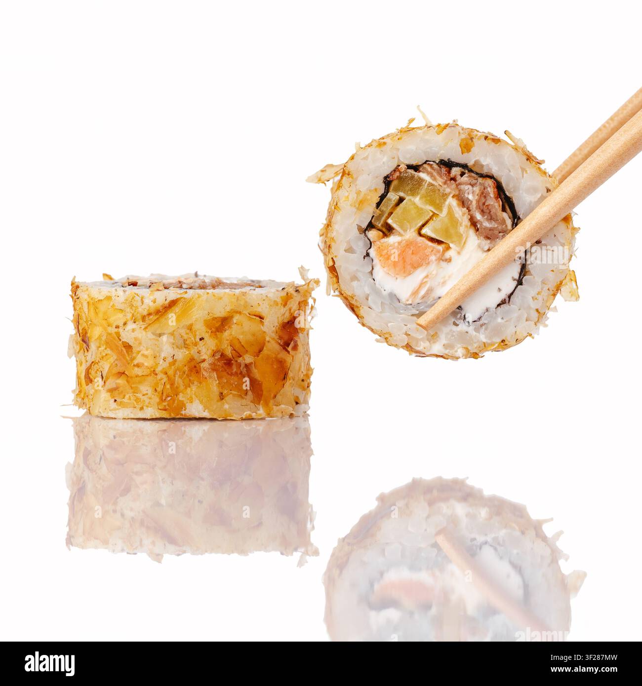 Essstäbchen halten eine köstliche Sushirolle mit Bonito-Flocken Stockfoto