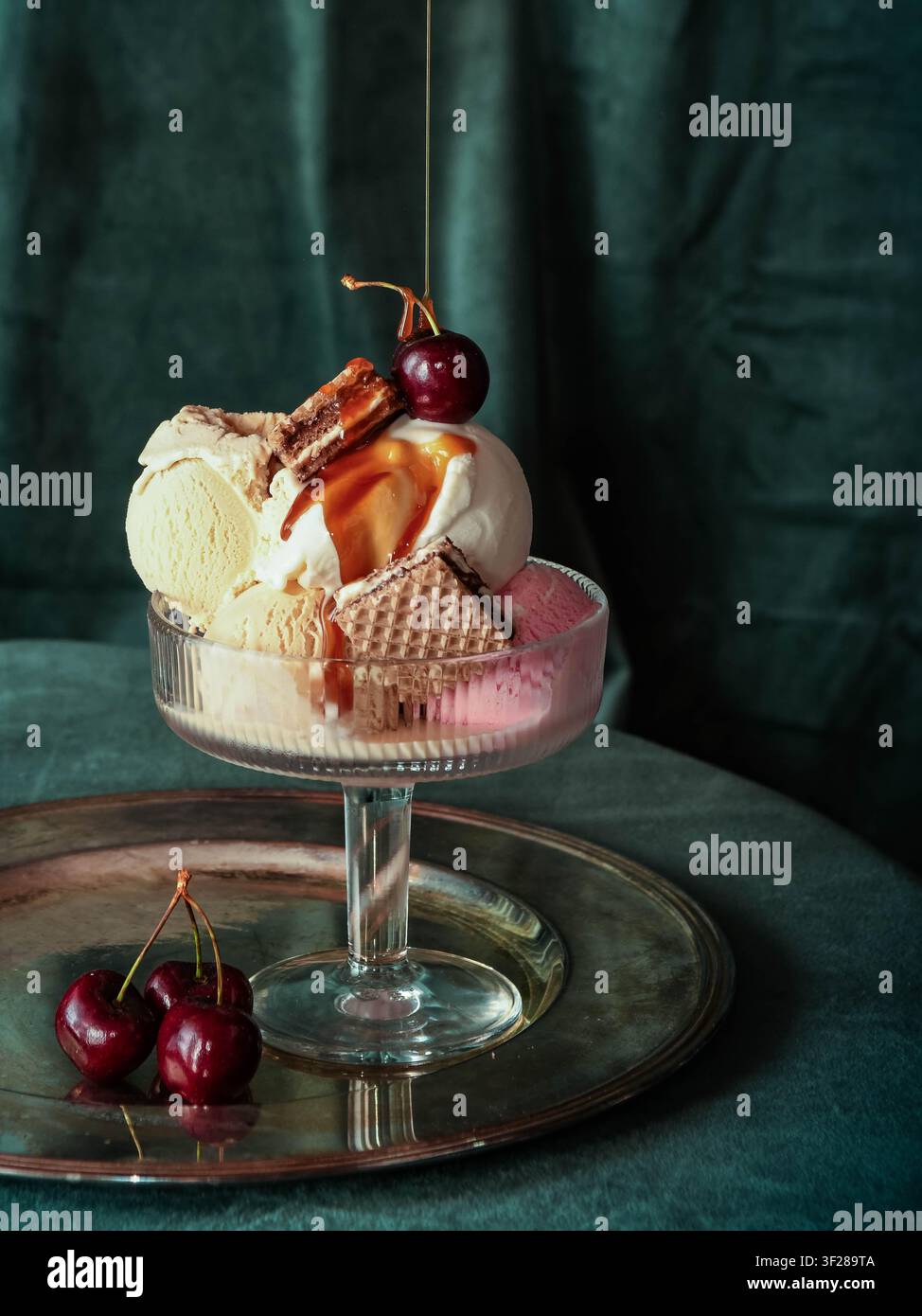 Gourmet-Eisbecher mit Karamellsoße und Kirschen Stockfoto