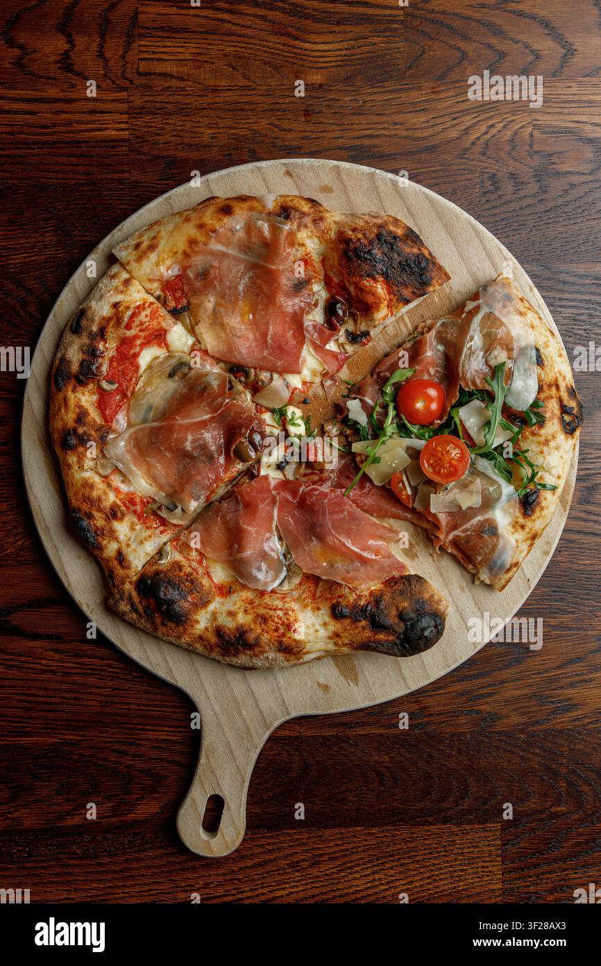 Frisch gebackene Pizza mit einer Scheibe einer anderen Pizza. Kunst. Stockfoto