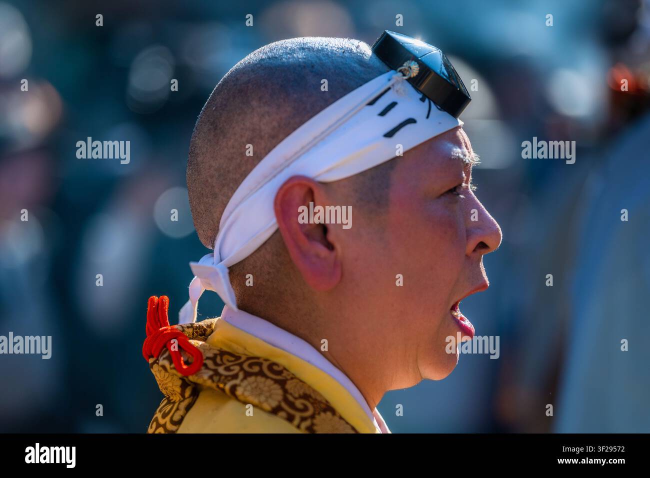 Ein Yamabushi-Mönch, der traditionelle Tokin-Kopfbedeckungen trägt, betet während der Feuerlauf-Zeremonie im Daisho-in-Tempel auf der Insel Miyajima in Japan. Stockfoto