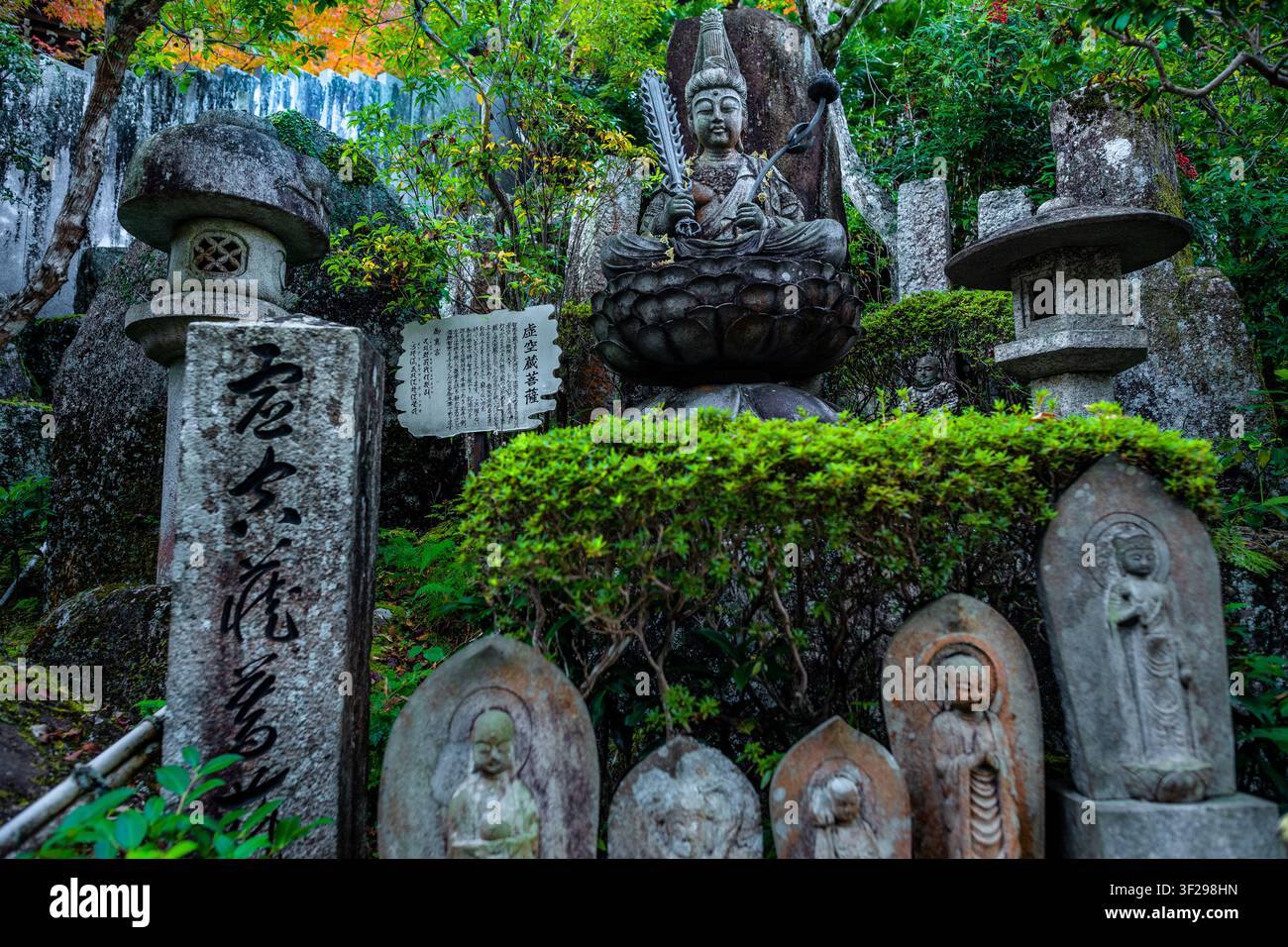 Eine Statue von Monju Bosatsu, dem Bodhisattva der Weisheit, ist entlang eines Weges zu sehen, der zum Daisho-in-Tempel auf der Insel Miyajima in Japan führt. Stockfoto
