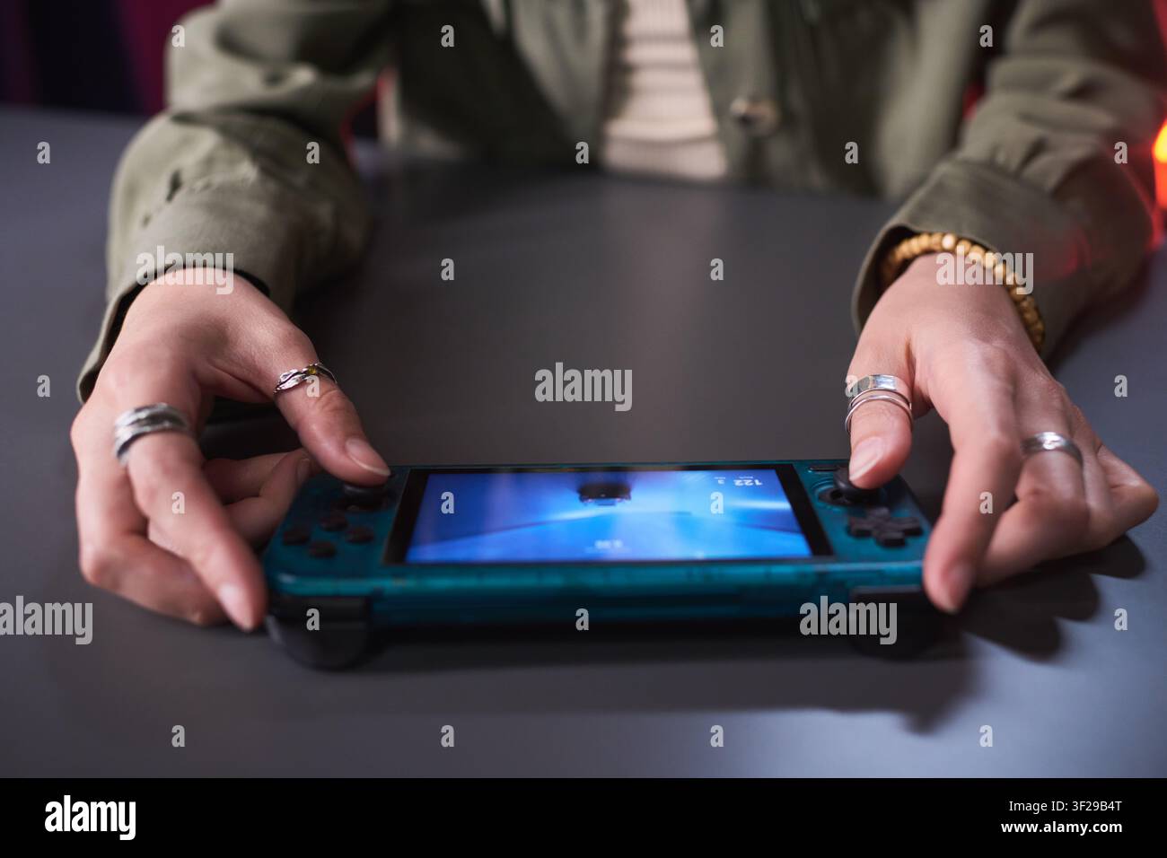Unbekannte Frau hält eine Handheld-Spielekonsole für Mobile Gaming Stockfoto