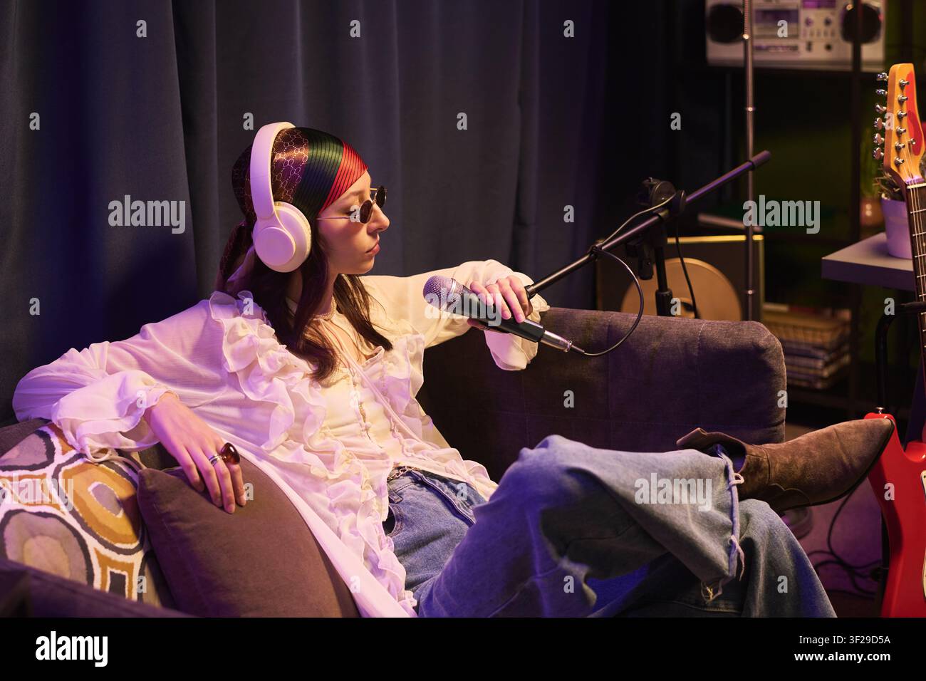 Frau nimmt Podcast in einem Heim-Musikstudio auf Stockfoto