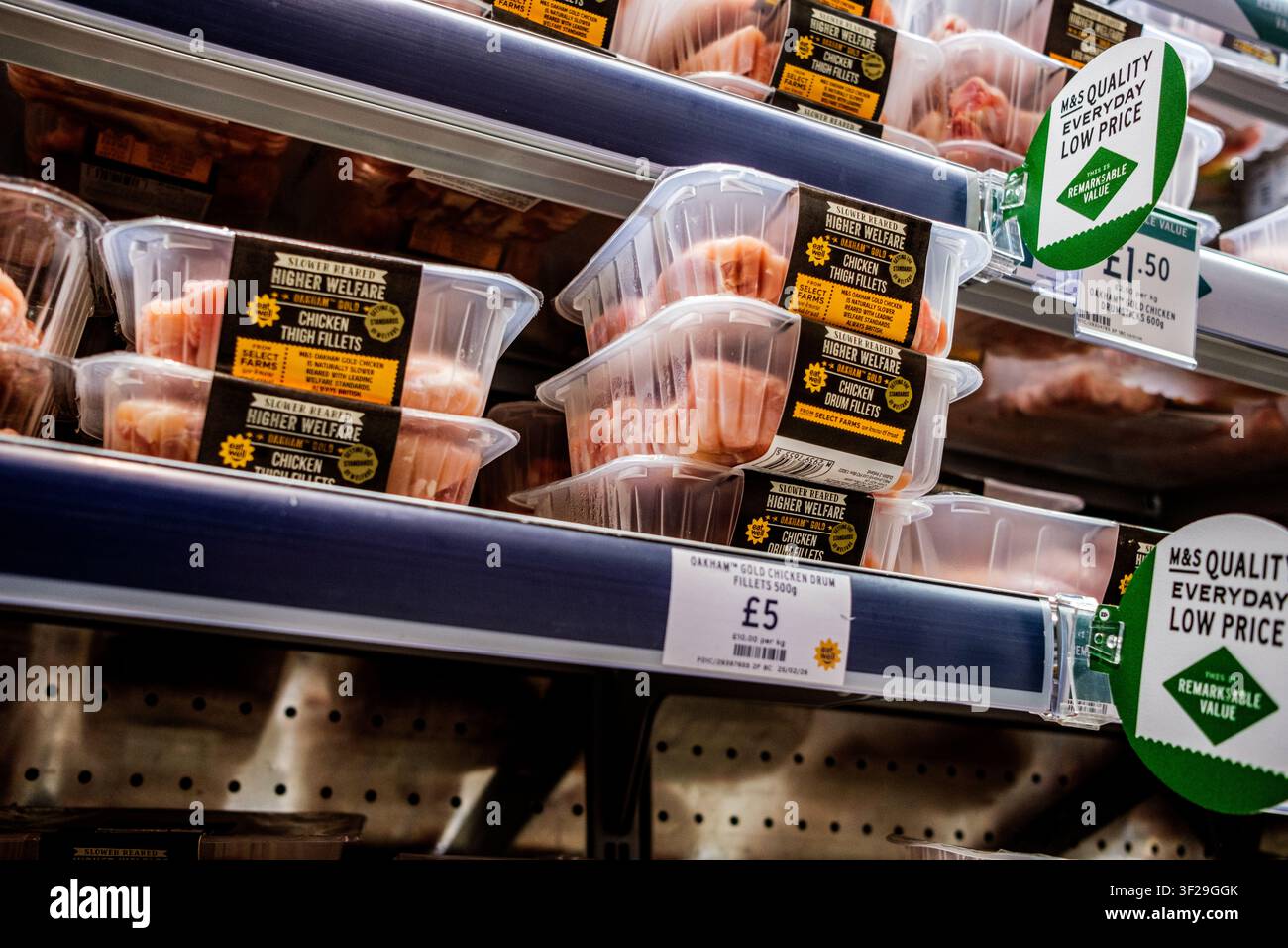 London UK, 17. Juli 2026, ordentlich angeordnete Packungen von rohen britischen Hühnerschenkelfilets und -drumsticks mit höherem Tierwohl in Marks und Spencer Stockfoto