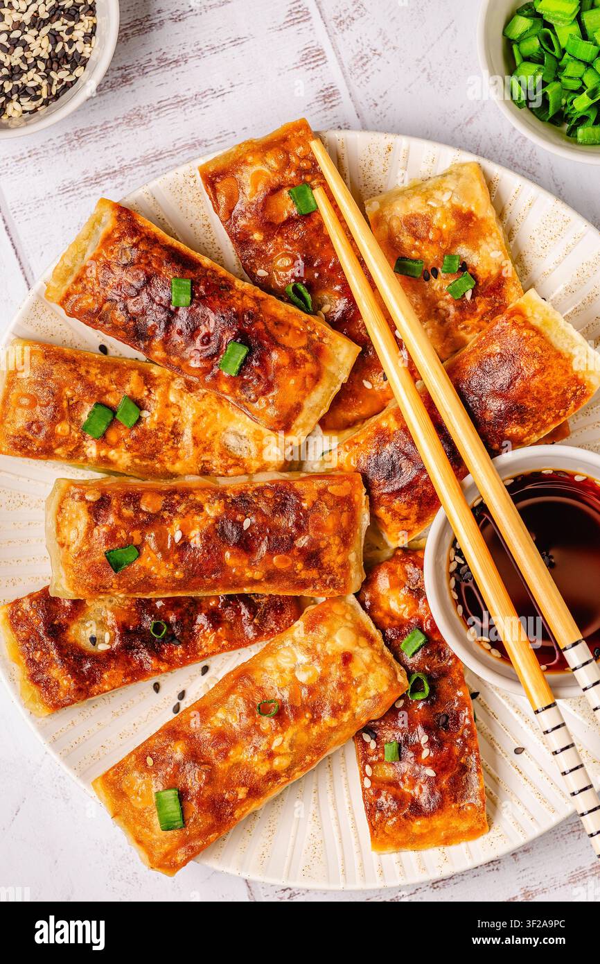 Knödel sind auf einem Teller angeordnet mit einer kleinen Schüssel Dip. Stockfoto