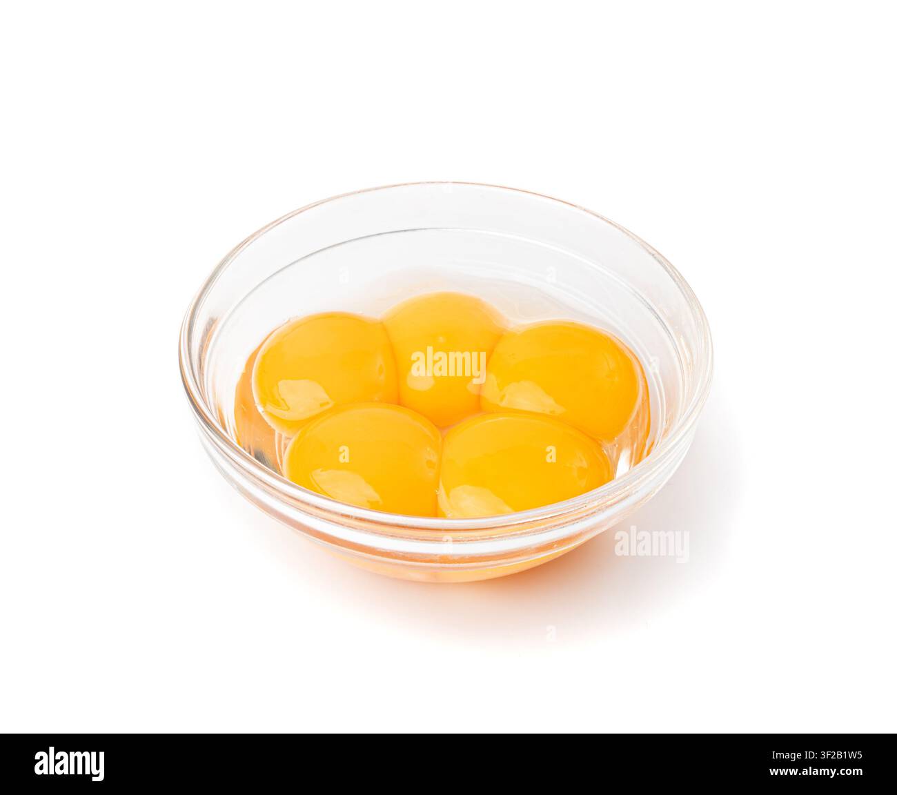 Eigelb in Schüssel, 5 frische Hühner-Eigelb von den Eiweiß getrennt für Kochrezept, fünf Bio-Eigelb in Glasschüssel Stockfoto