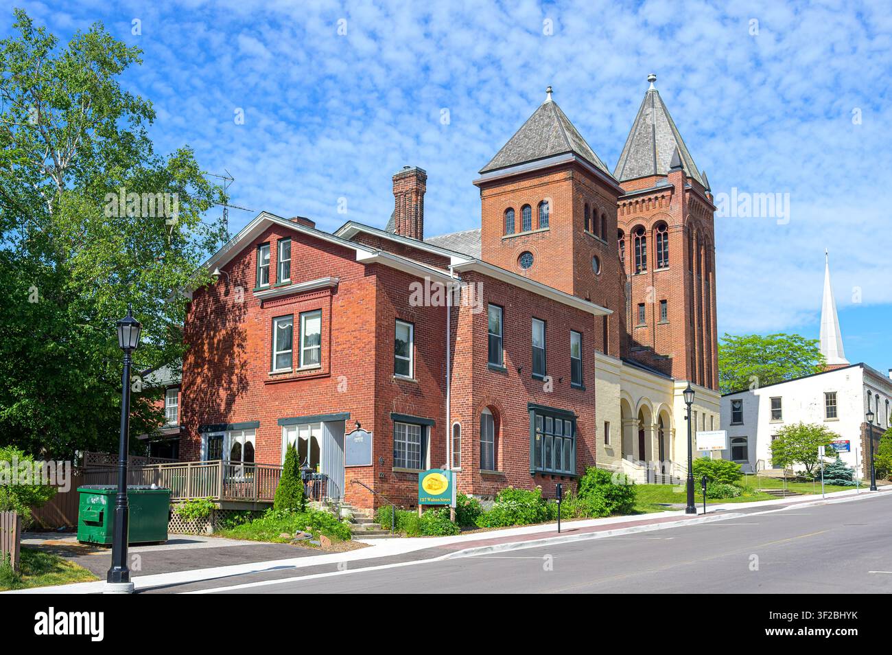 Summerhill Manor und St. Paul's Presbysterian Kirche. Historische rote Backsteinkirche und Erbegebäude entlang einer ruhigen Innenstadtstraße unter einem blauen Himmel. Stockfoto