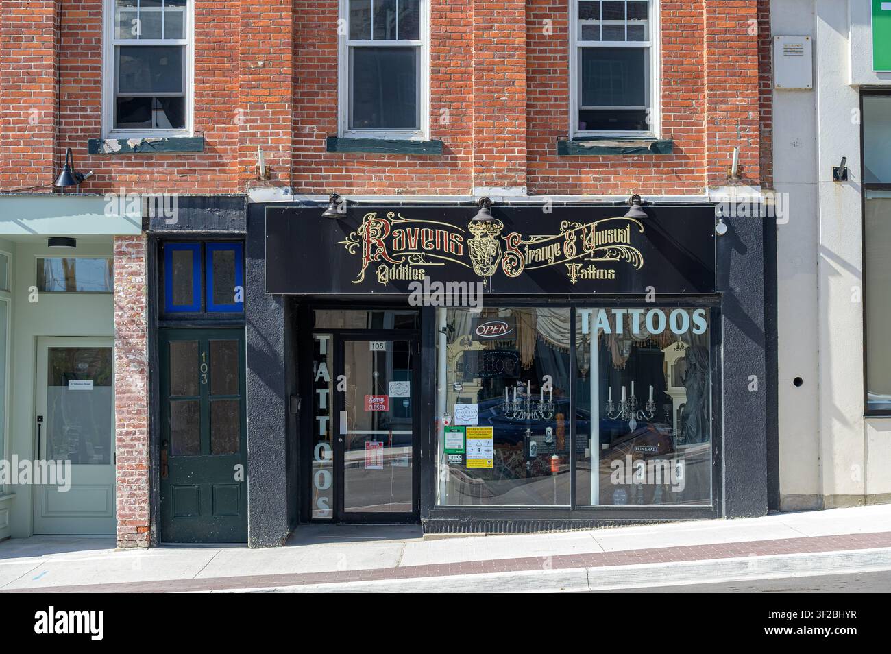 Historische Ladenfront eines Tattoo-Studios (Ravens Strange & Unusual) in einem restaurierten roten Backsteingebäude. Stockfoto