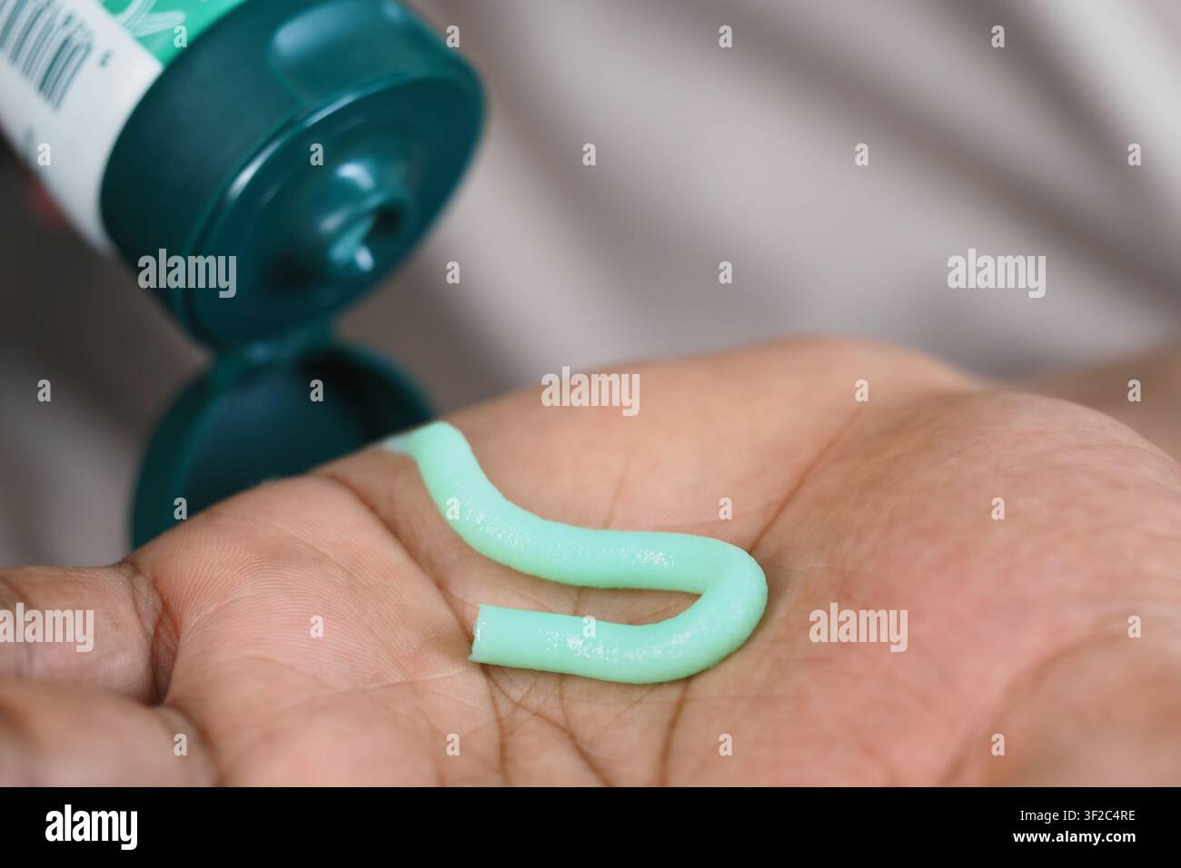 Hand mit grünem Gel in einer Pflegeumgebung Stockfoto