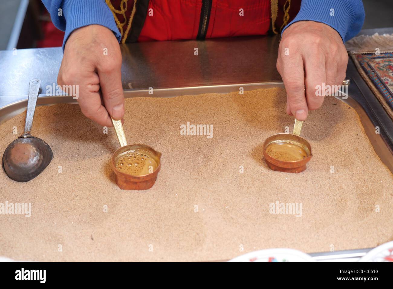 Türkischen Kaffee in Tonbechern auf erhitztem Sand auf einem Markt zubereiten Stockfoto