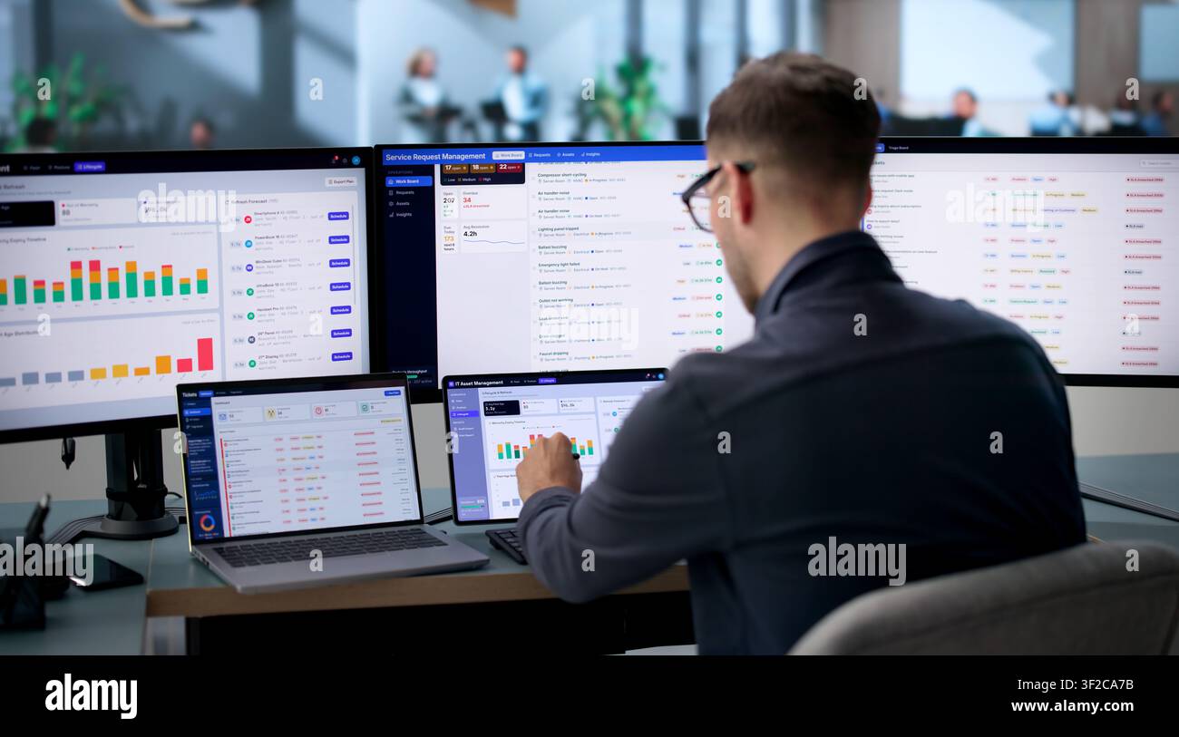 Einrichtungsmanager verwendet einen Laptop, um Wartungsanfragen zu verfolgen und Reparaturen zu verwalten. Stockfoto