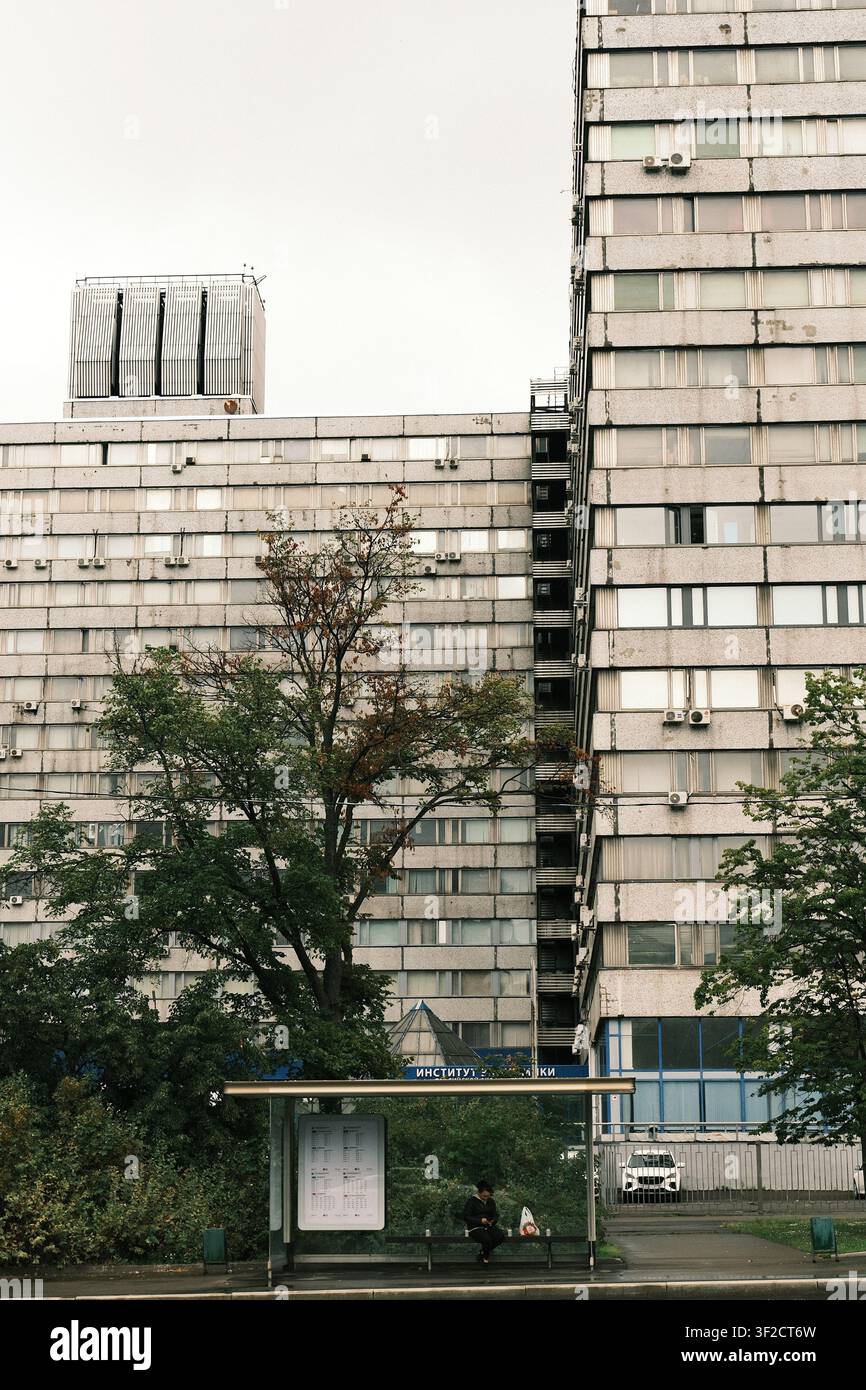 Imposante späte-sowjetische modernistische Betonfassade mit sich wiederholendem Rasterfenster und Klimageräten unter einem bewölkten Himmel in Moskau. Stockfoto