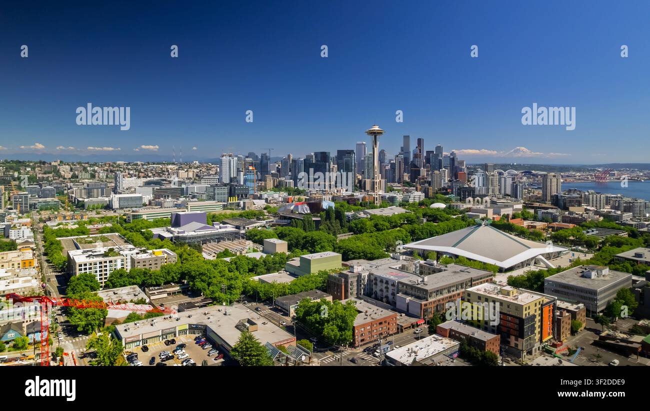 Seattle, Vereinigte Staaten - 15. Juli 2026: Luftaufnahme des Space Needle und der Innenstadt-Skyline mit Climate Pledge Arena, üppigen Bäumen und Mount Rainier i Stockfoto