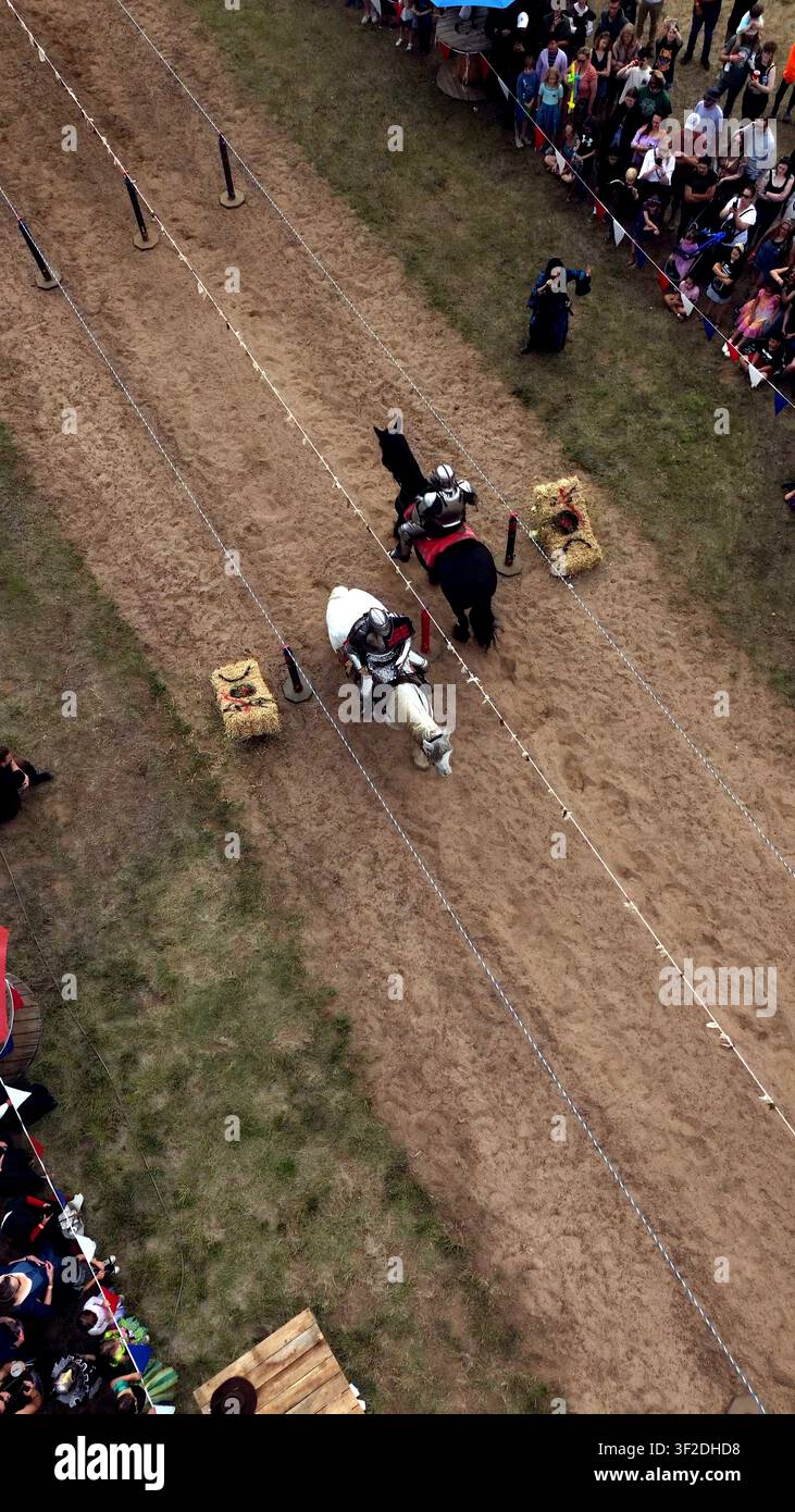 Loveland, Colorado, Vereinigte Staaten - 09. Juni 2024: Luftaufnahme des Colorado Medieval Festival mit Rittern in Rüstung, die auf Pferden auf einer Schotterbahn reiten, w Stockfoto