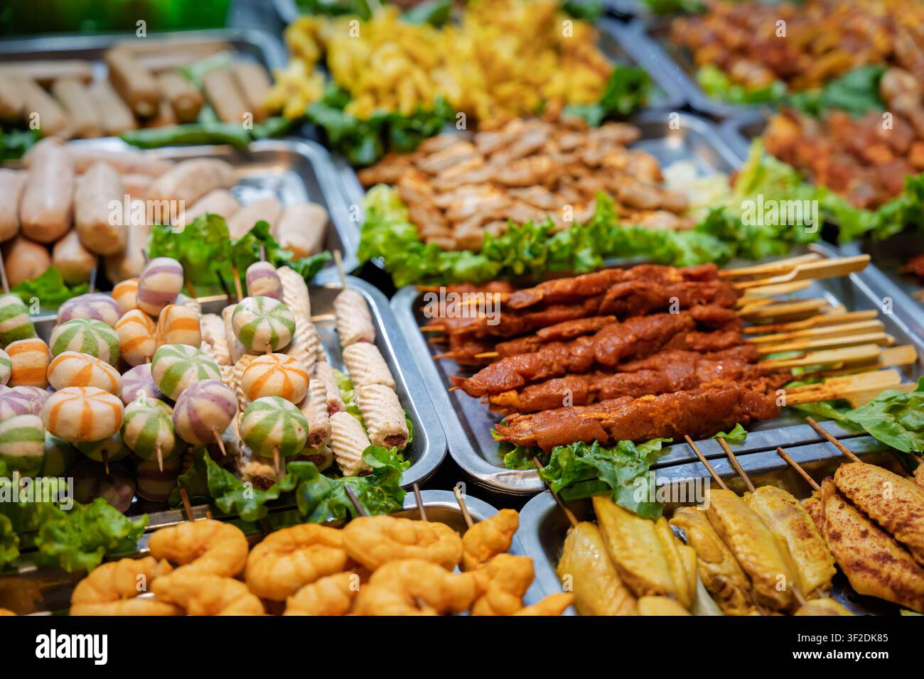 Verschiedene gegrillte Fleischsorten, Würste, Knödel und Gemüse, die an einem lebhaften Straßenimbiss in Sa Pa, Lao Cai, Vietnam, ausgestellt sind. Stockfoto