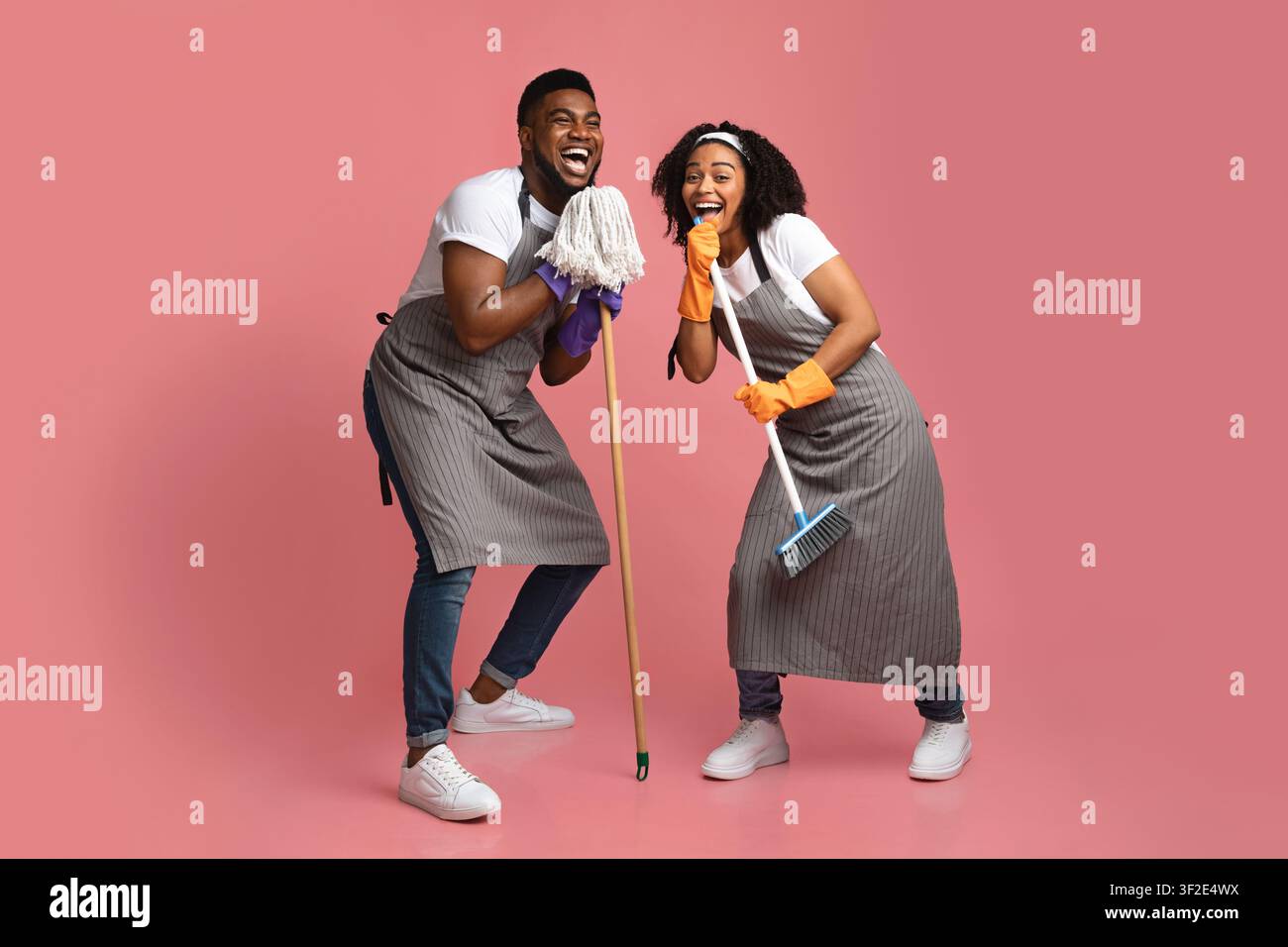 Inlandsband. Glückliches Afroamerikanisches Paar, Das Beim Putzen Der Wohnung Zusammen Täuscht Stockfoto