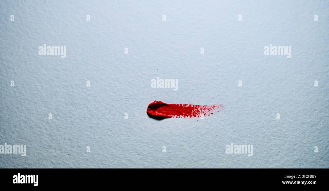Heller roter Pinselstrich auf weißem strukturiertem Aquarellpapier. Stockfoto