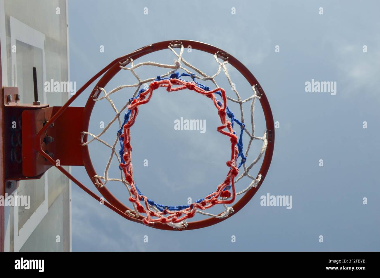 Nahaufnahme eines Basketballkorbs, des Rings und des Netzes vor einem klaren blauen Himmel auf einem Außenspielfeld. Sport, Freizeit, Fitness und Wettkampf. Stockfoto