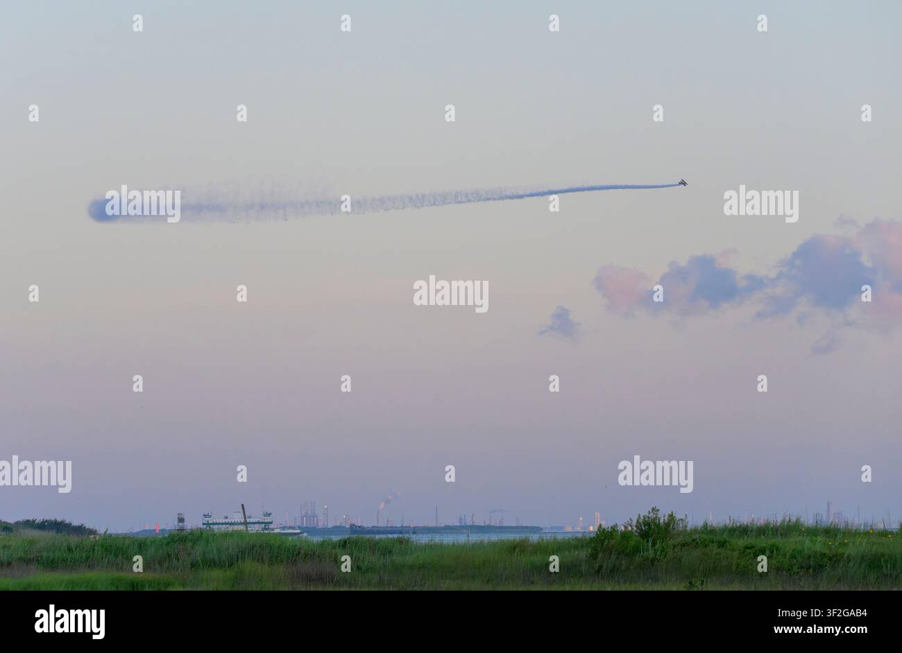 Luftmäßige Moskitobehandlung von einem Flugzeug bei Sonnenaufgang über die Feuchtgebiete von Galveston Island vor dem 4. Juli-Gedenken, Galveston, Texas, USA. Stockfoto