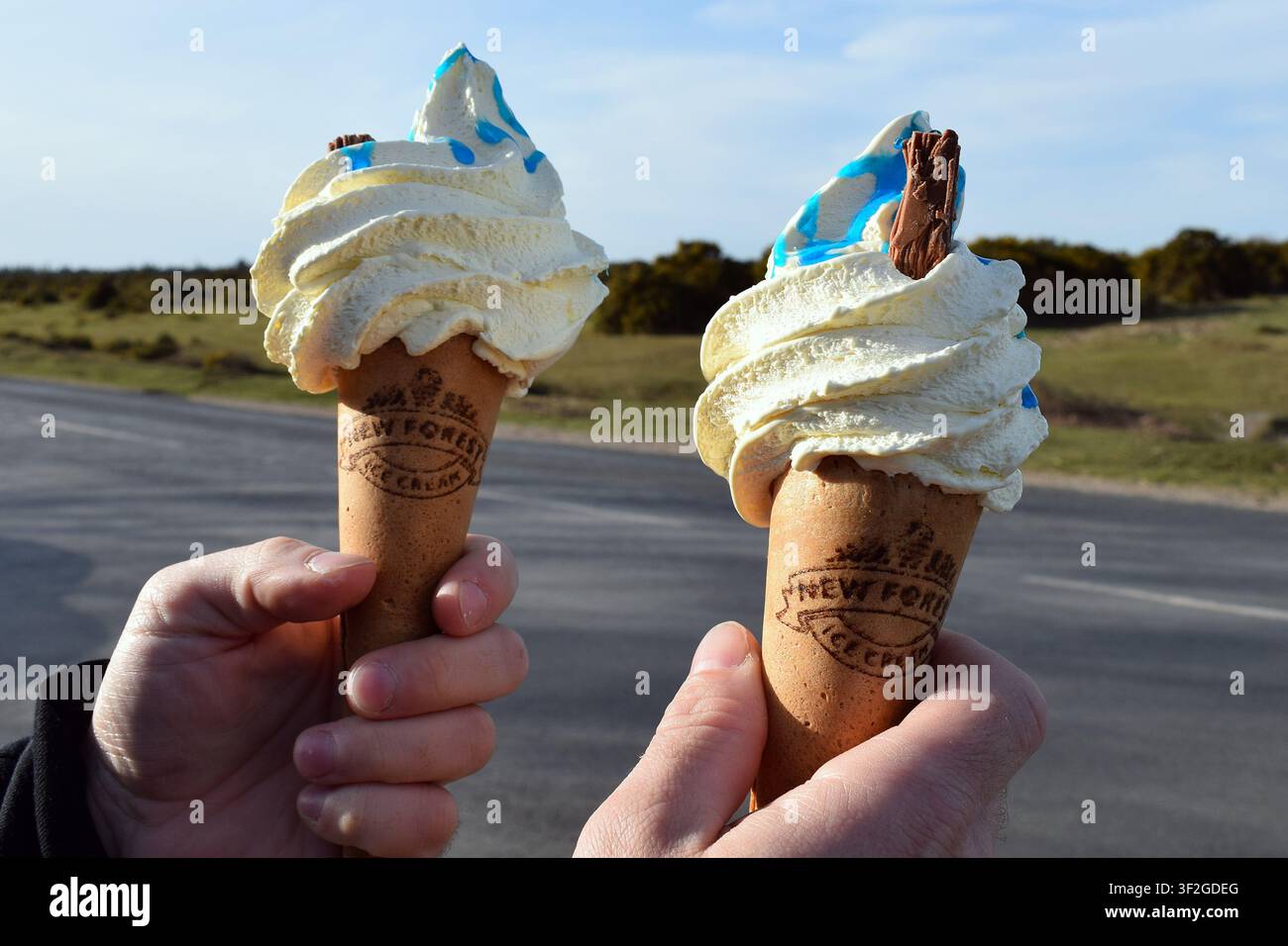 Zwei Vanille-Eiswaffeln, die im New Forest, Hampshire, England, im Freien gehalten werden Stockfoto