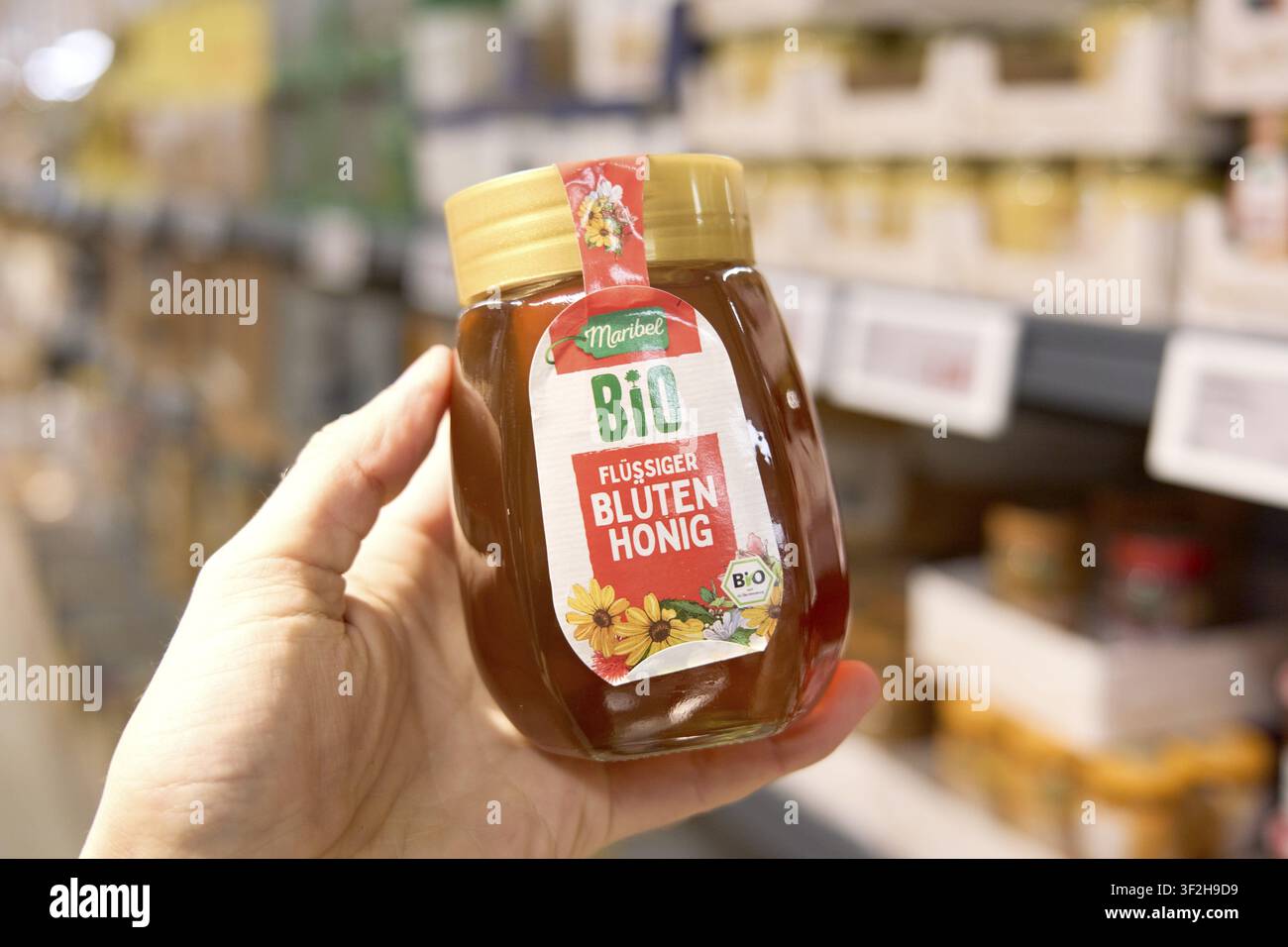 Maribel Flüssiger organischer Blütenhonig in einem Glas mit floralem Dekorationsmotiv wird im Supermarkt gezeigt, Lidl Lebensmittelladen Discounter, Supermarkt Stockfoto