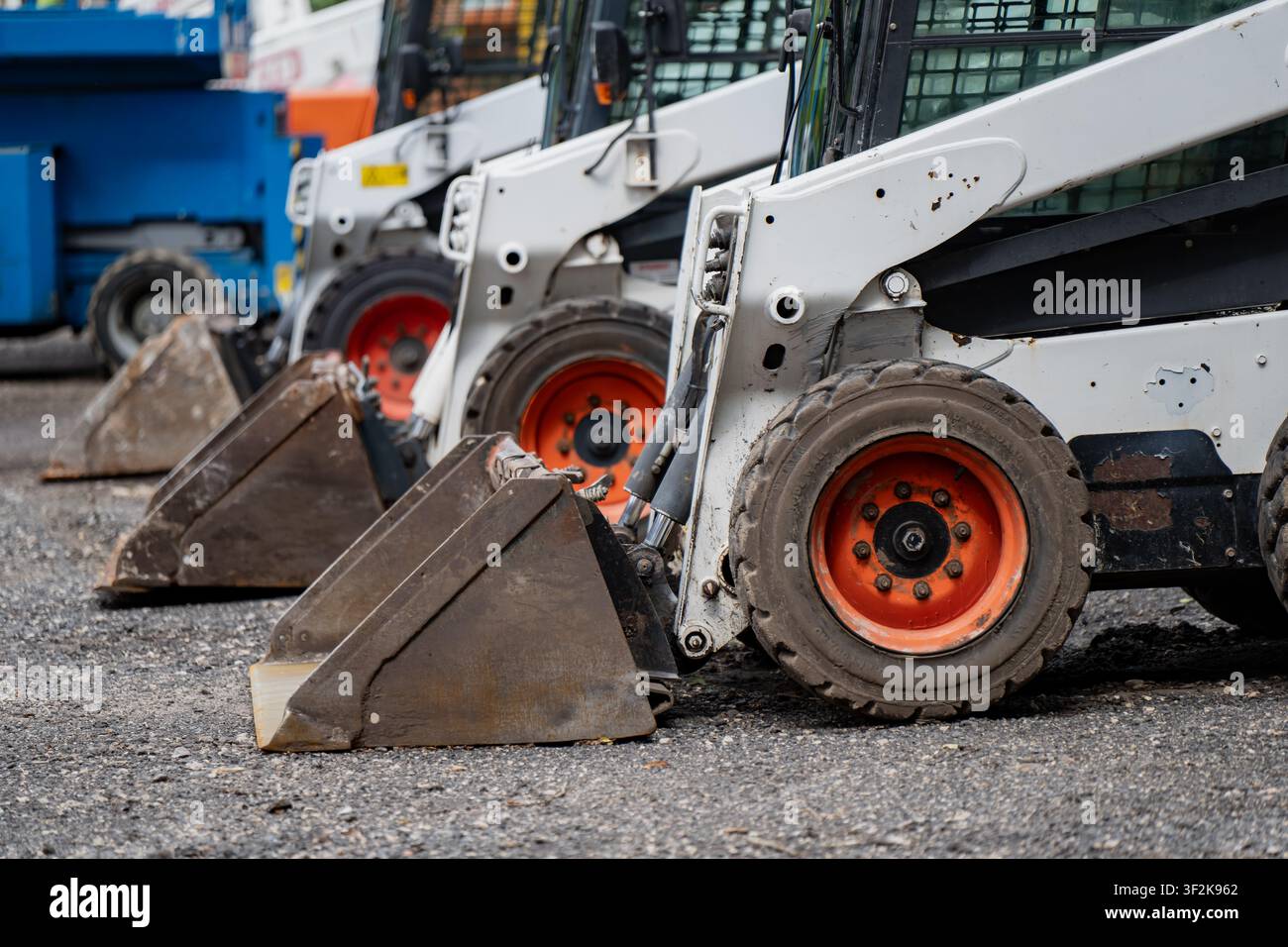 Kommerzielle Frontlader-Traktoren in einer geordneten Reihe geparkt, die die Branchen für Geräteleasing und zivile Infrastrukturentwicklung symbolisieren Stockfoto