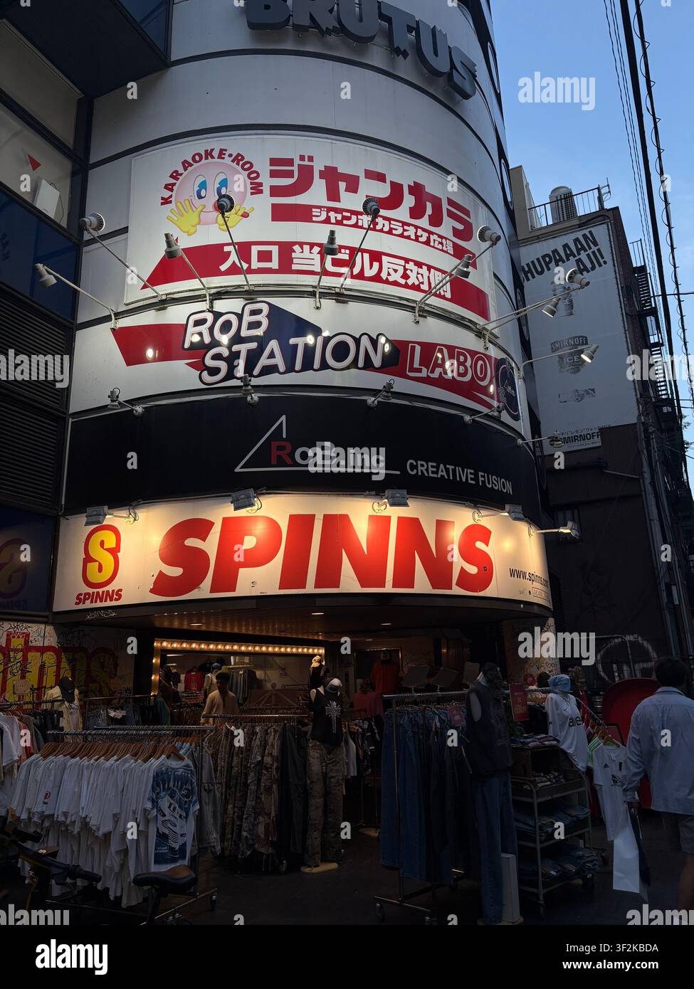 28. Juli 2025, Osaka, Japan – Lebhafte Fassaden von Gewerbegebäuden mit Karaoke-, Mode- und Unterhaltungsgeschäftsschildern auf Japanisch und Englisch, Stadtteil von Osaka. Stockfoto