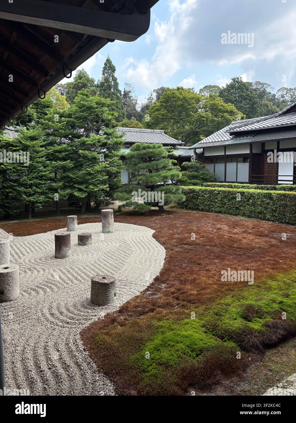 1. August 2025, Kyoto, Japan – Traditioneller japanischer Zen-Garten (Karesansui) mit geharktem Kies, Steinlaterne, Moos und beschnittenen Kiefern in einem Tempel in Kyoto. - Smartphone-aufgenommenes Stockfoto