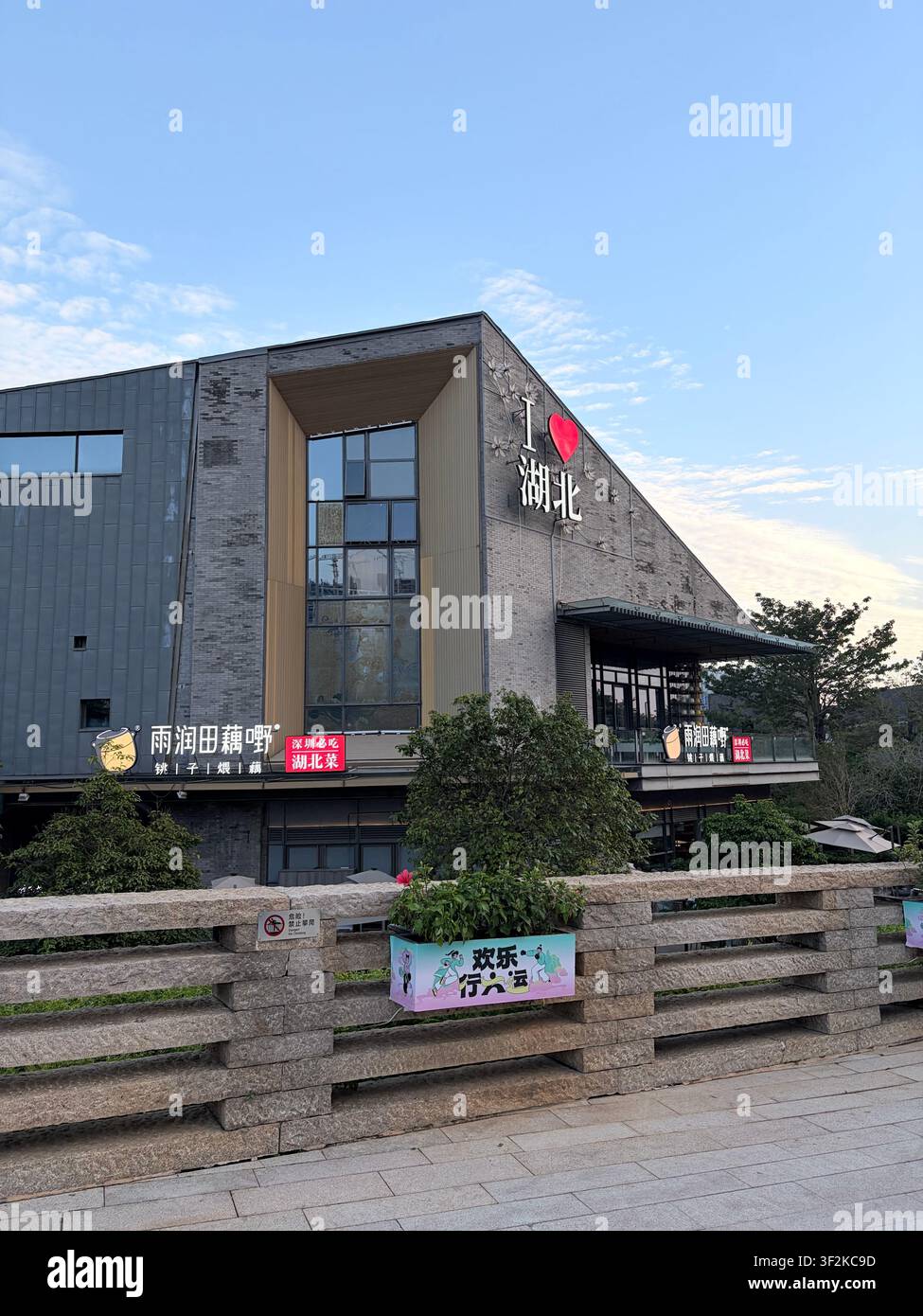 25. Oktober 2025, Nanshan-Bezirk, Shenzhen, China – Moderne Fassade eines Gewerbegebäudes mit chinesischer Schriftbeschilderung und Werbebannern im Nanshan-Bezirk. - Smartphone-aufgenommenes Stockfoto