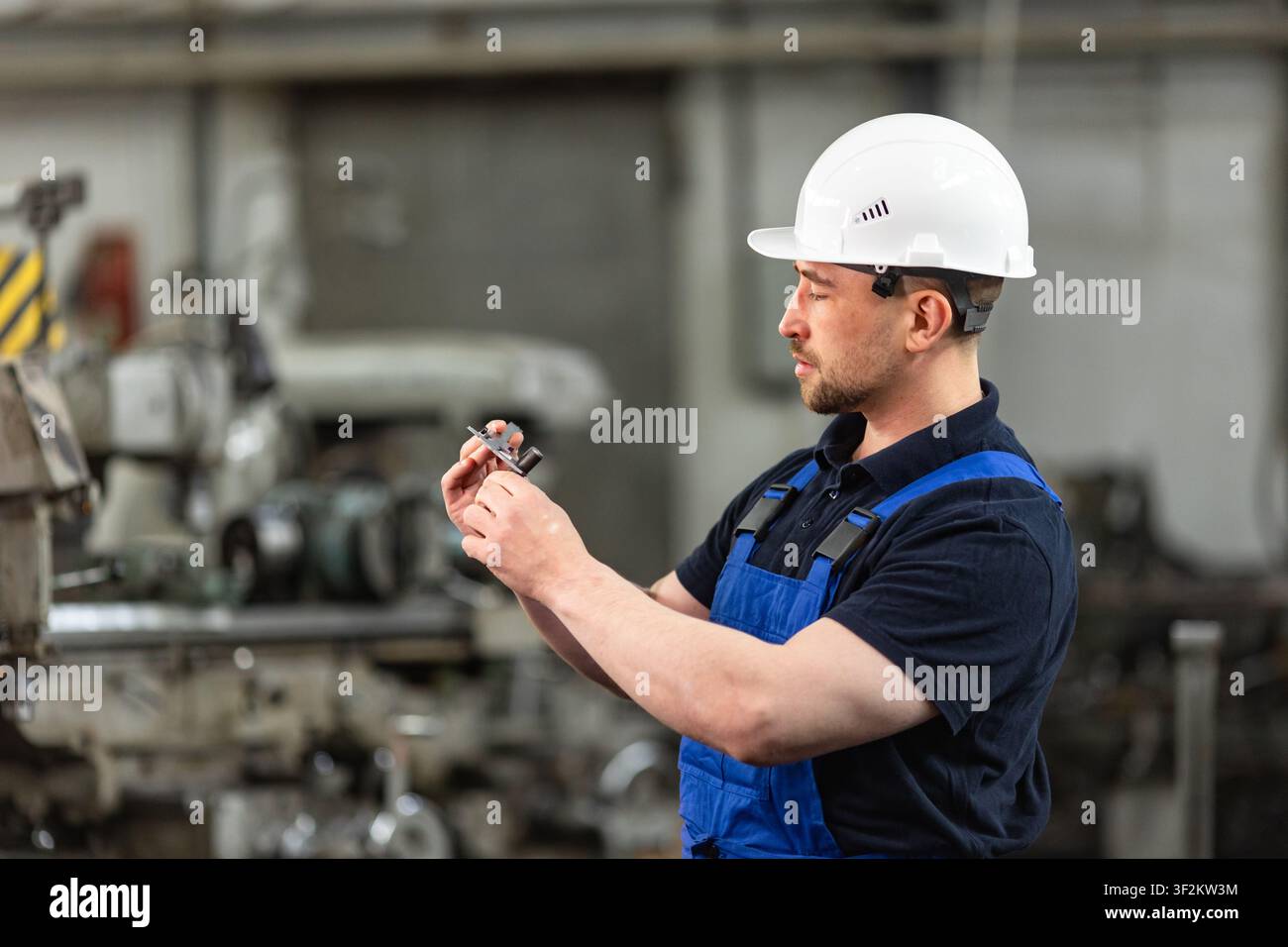 Industriemechaniker inspiziert Präzisionsteil in einer Fertigungsfabrik Stockfoto
