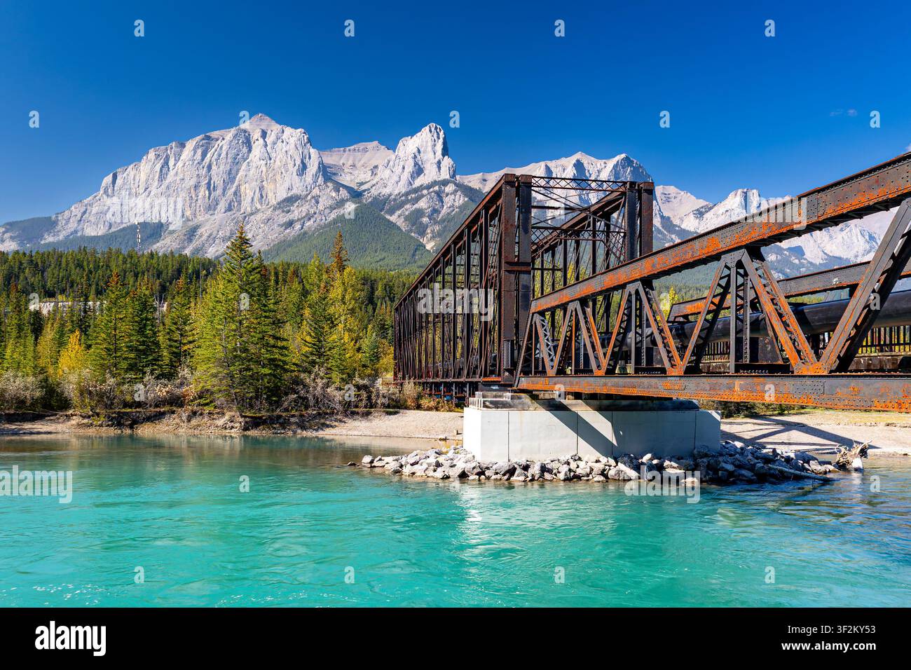 Historische Canmore-Enginebrücke über den türkisfarbenen Bow River mit Mount Rundle und den Rocky Mountains im Hintergrund, Alberta, Kanada. Stockfoto