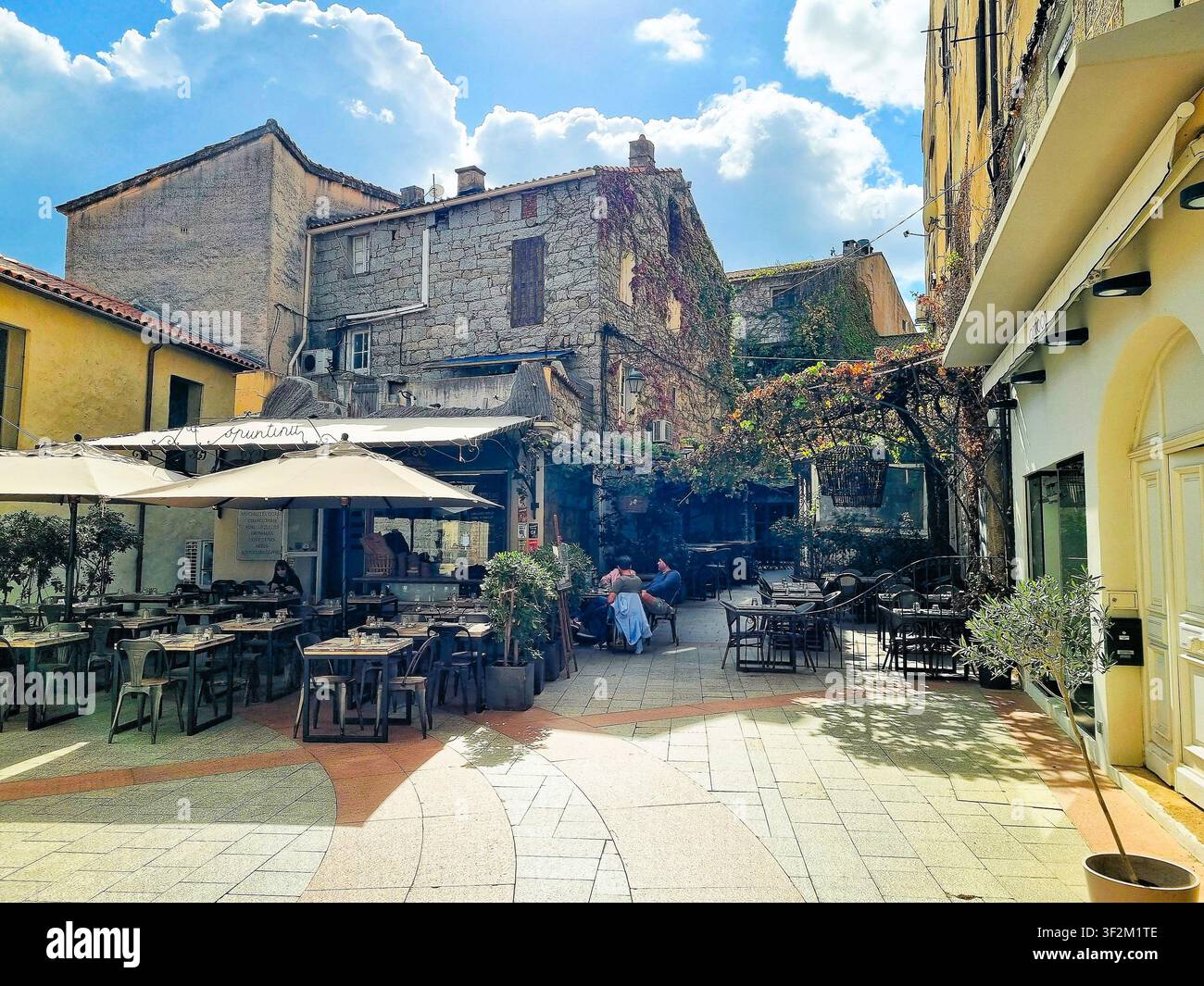 Restaurantterrasse mit antiken Gebäuden im Hintergrund in Porto-Vecchio, Korsika, Frankreich Stockfoto