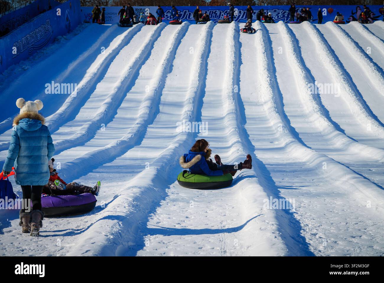 Menschen genießen Snowtubing auf einem schneebedeckten Hang. Stockfoto