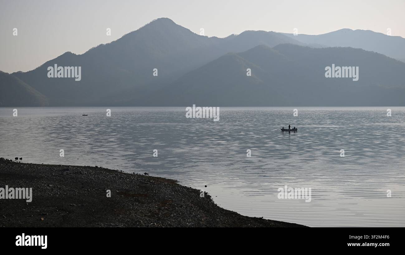 Ruderboote auf den ruhigen Gewässern des Chuzenji-Sees (Chuzenjiko) im Nikko-Nationalpark, Präfektur Tochigi, Japan. Der malerische Bergsee, der durch t Stockfoto
