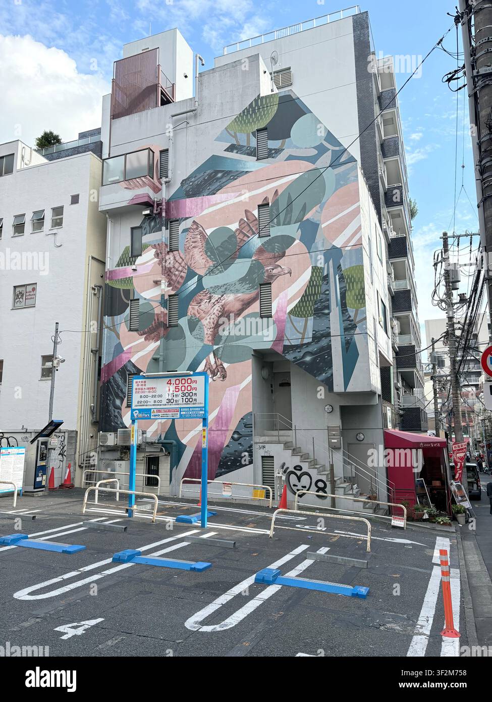 16. August 2025, Suginami, Tokio, Japan – Großes farbenfrohes Straßenkunst-Mural mit fliegenden Falken, das auf der Fassade eines Gebäudes im Bezirk Suginami in Tokio gemalt ist. - Smartphone-aufgenommenes Stockfoto