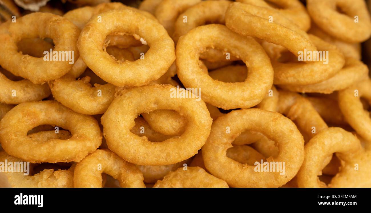 Calamari-Ringe-Muster, frittiere-Speise texturierter Hintergrund, Zwiebelringe Nahaufnahme und Oberansicht Stockfoto