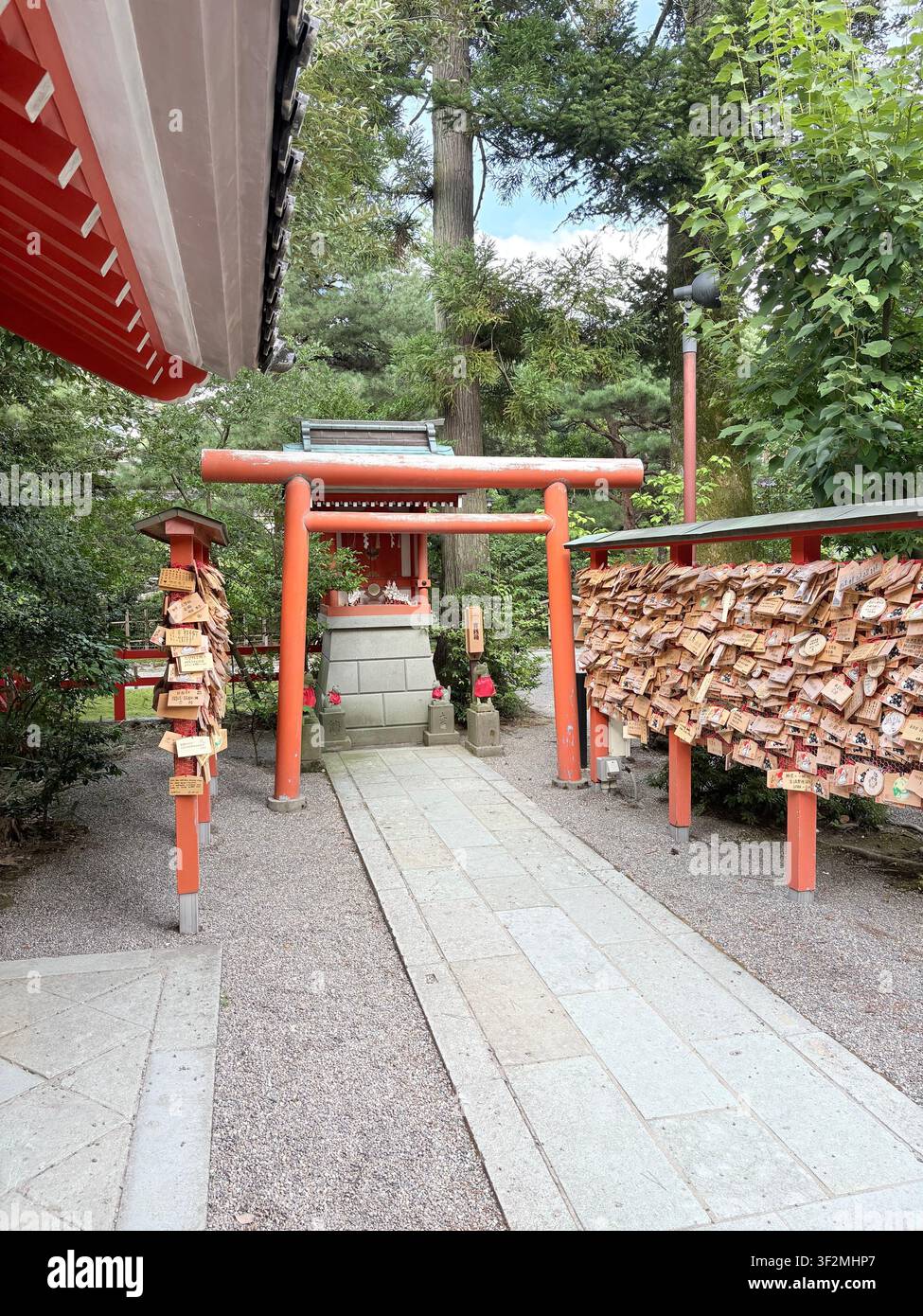 3. September 2025, Kanazawa, Japan – Rotes Torii-Tor mit Hunderten von ema-Holztafeln mit japanischen Kanji als Wunschtafeln an einem Shintoschrein in Kanazawa. - Smartphone-aufgenommenes Stockfoto