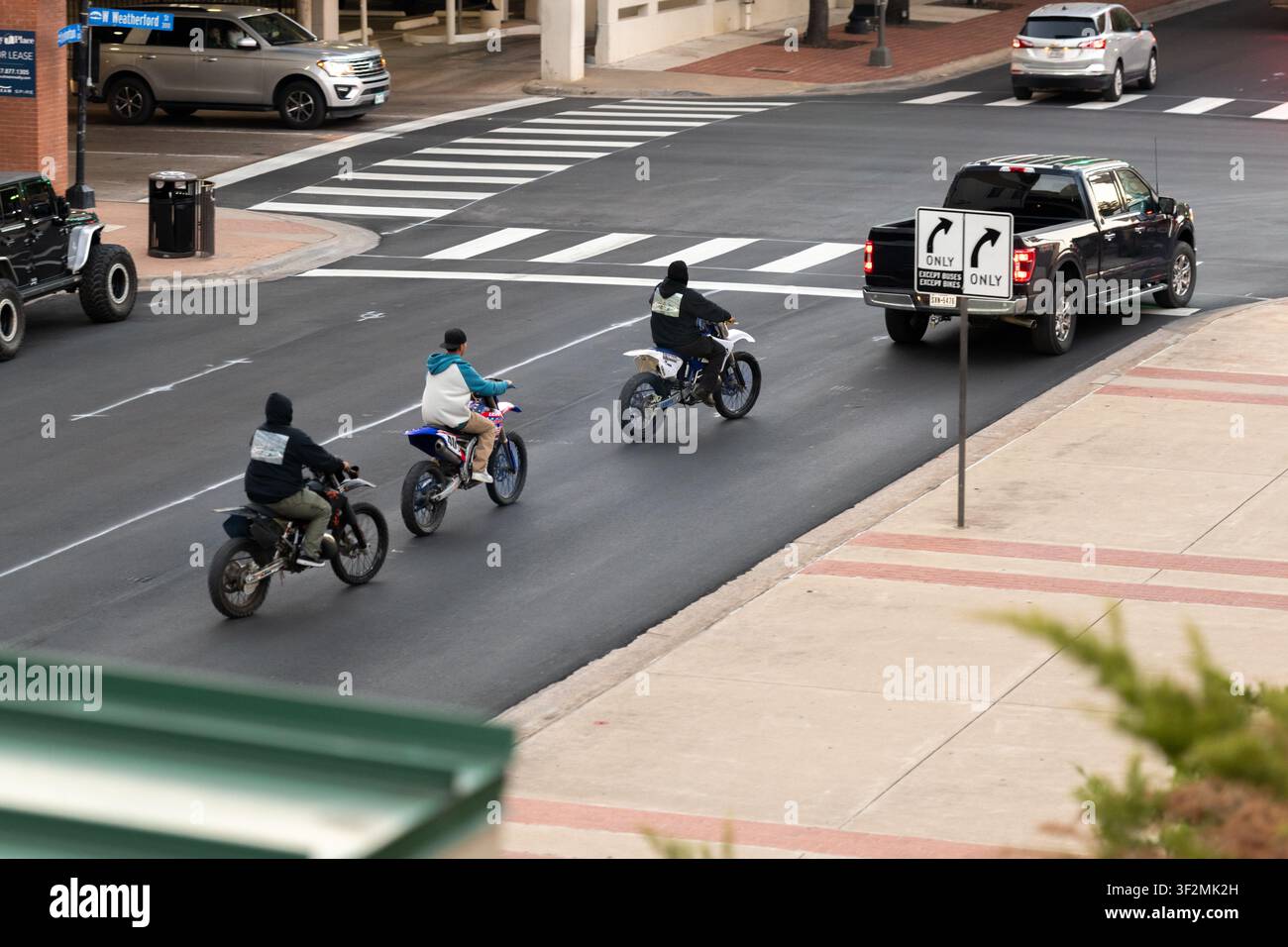 Drei Fahrer fahren Geländemotorräder auf einer Innenstadtstraße in Fort Worth, Texas, USA Stockfoto