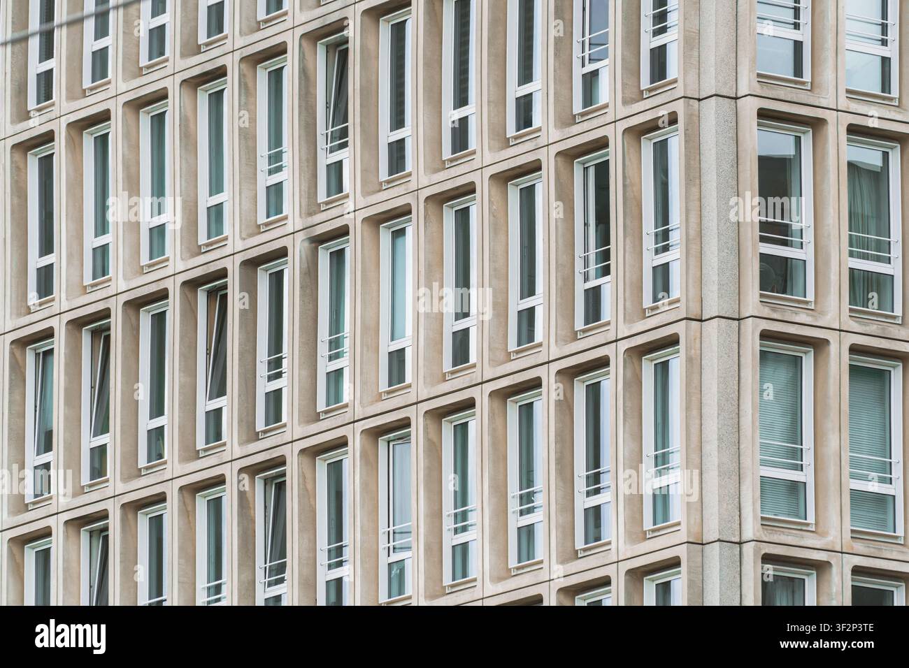 Minimalistische Bürofassade mit sich wiederholendem Fensterpattern und klaren architektonischen Linien, geometrische Formen, abstrakte architektonische Komposition eines Modernen Stockfoto