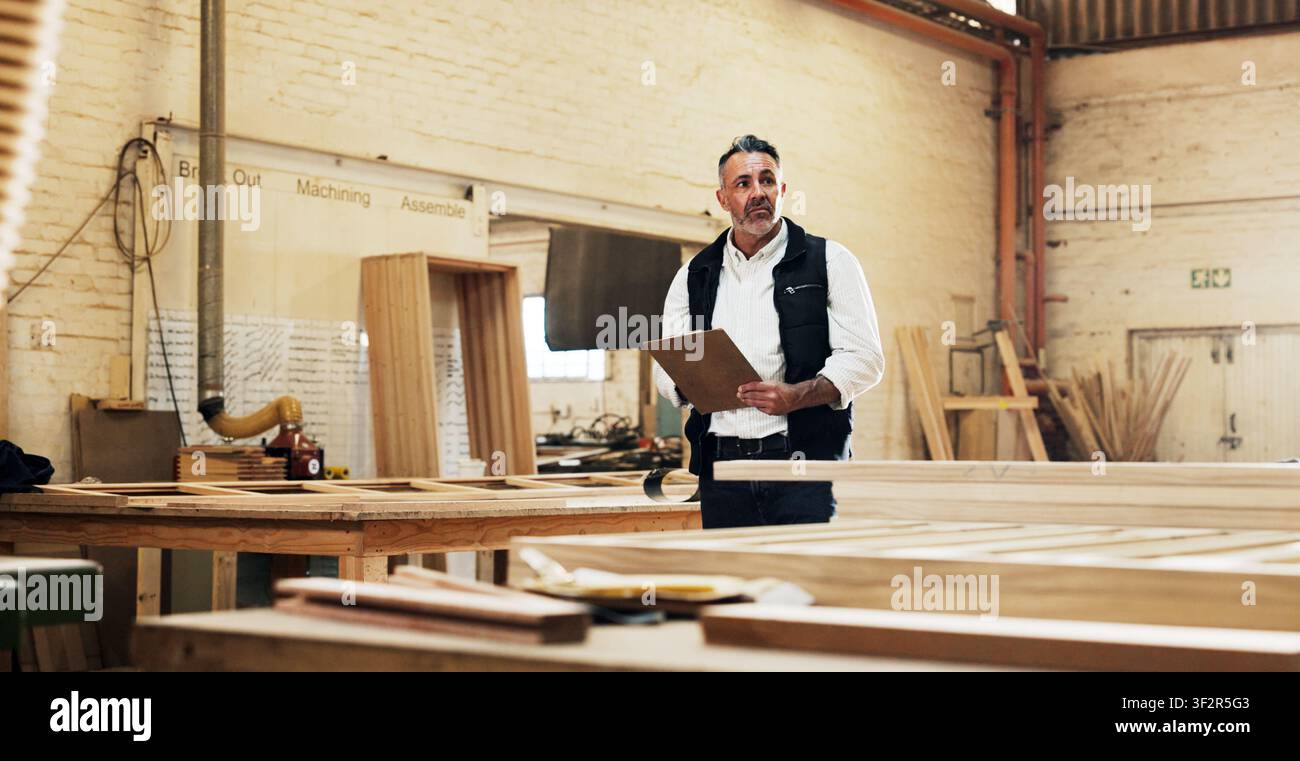 Kleines Unternehmen, Inspektion und Mann mit Klemmbrett in einer Tischlerwerkstatt zur Qualitätskontrolle. Fertigung, Holzfabrik und reife Person mit Stockfoto