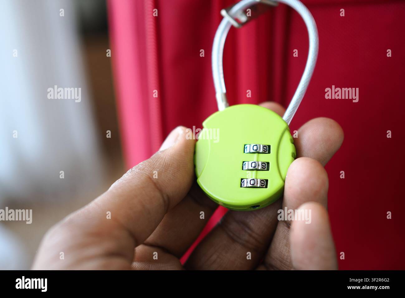 Schloss, das an der Hand gezeigt wird, bevor es am Gepäck verwendet wird Stockfoto
