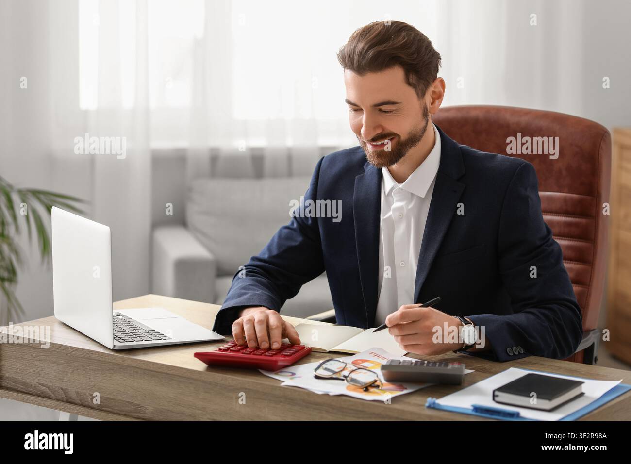 Ein Buchhalter, der im Amt Berechnungen macht Stockfoto