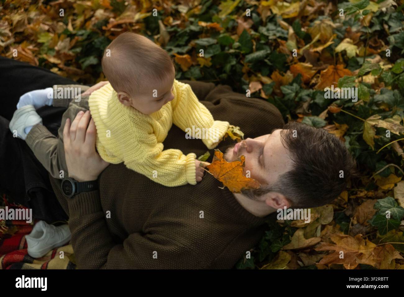 Fröhliches Baby spielt draußen im Herbst Stockfoto