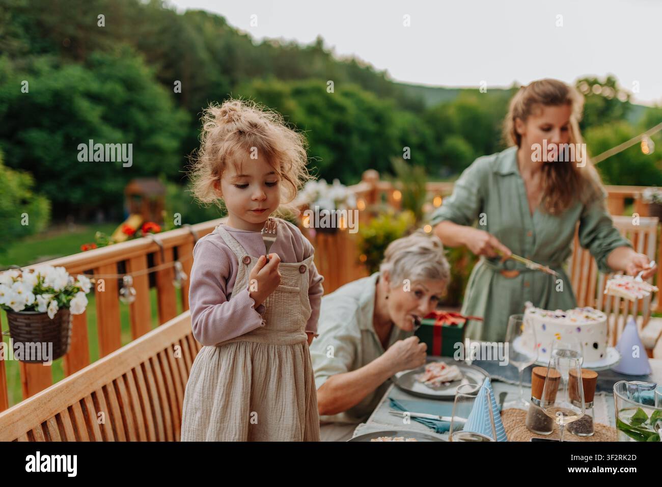 Familie genießt Geburtstagskuchen während einer Feier im Freien. Stockfoto