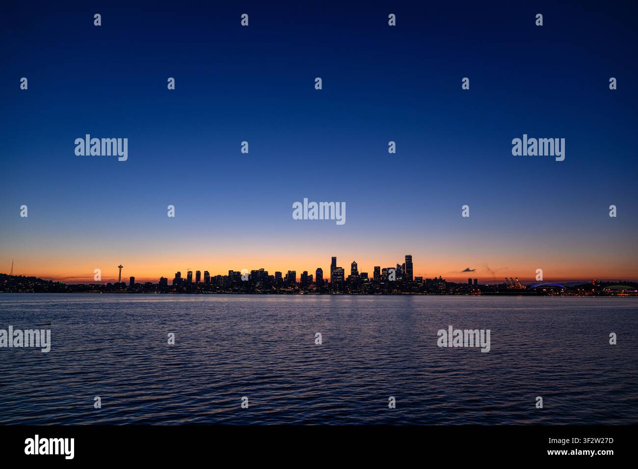 Blick auf die Skyline von Seattle bei Dämmerung von der Don Armeni Boat Ramp aus, mit dem Space Needle und Wolkenkratzern, die sich vor einem Sonnenuntergangshimmel abzeichnen, Seattl Stockfoto