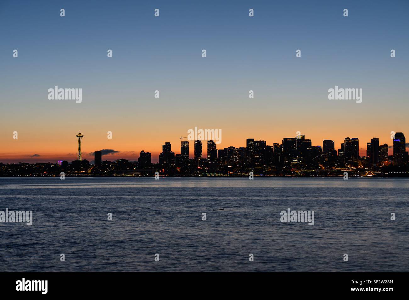 Blick auf die Skyline von Seattle bei Sonnenuntergang mit der Silhouette des Space Needle vor dem farbenfrohen Abendhimmel über dem Wasser in Seattle, Washington, Unite Stockfoto