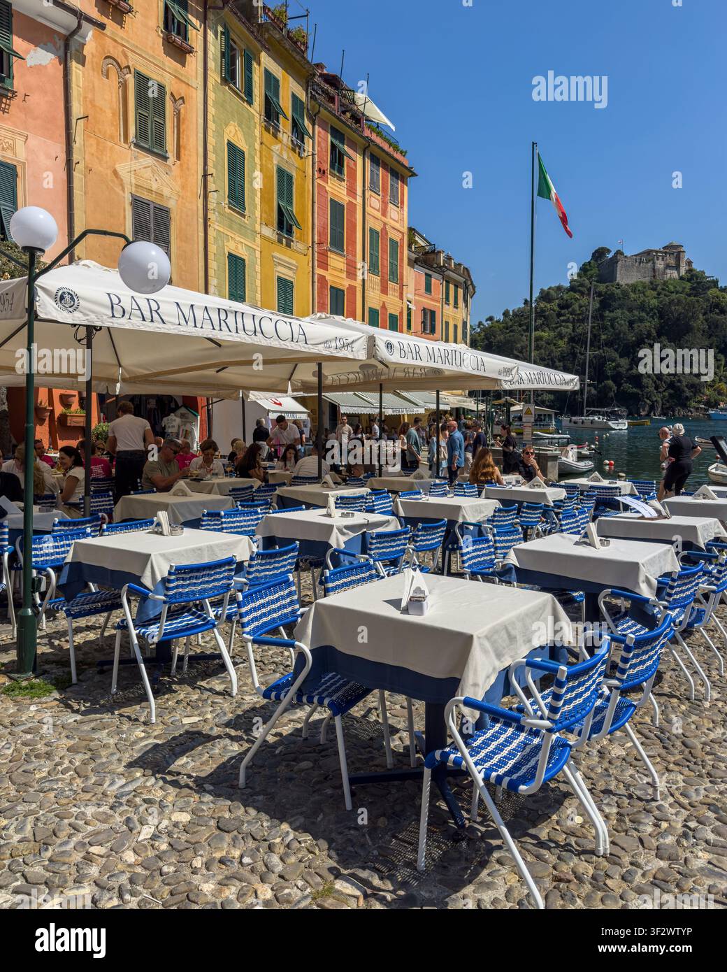 Lebendiger Platz in Portofino mit Außentischen eines Cafés und typischen farbenfrohen Häusern, Ligurien, Italien Stockfoto