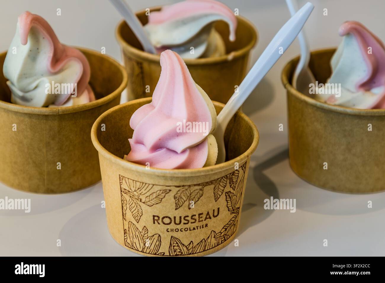 Weich Eis mit Beerenschwirl in Tassen von Confiserie Rousseau Chocolatier. Das Unternehmen, das sich auf preisgekrönte Schokoladen spezialisiert hat, serviert in dieser Filiale auch Weich Eis. Halifax, Neuschottland, Kanada Stockfoto